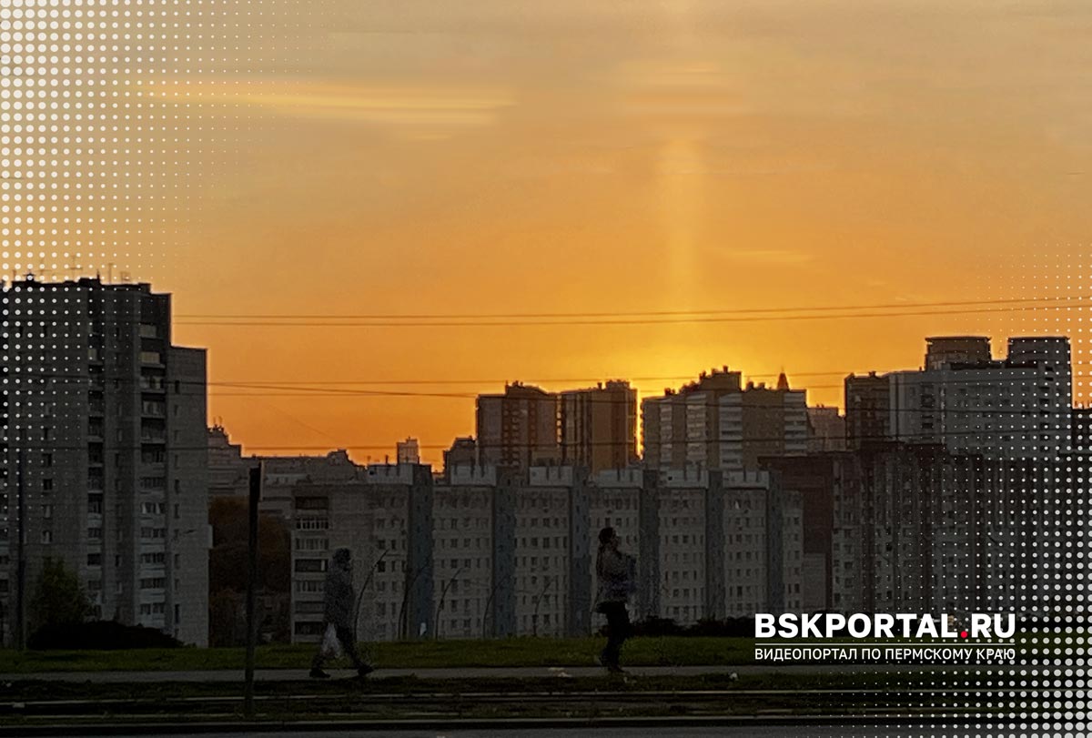 Оранжевый закат со световым столбом над многоэтажками спального района Перми